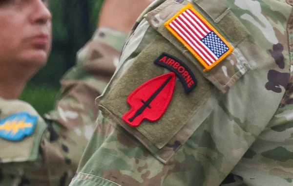 Détail des insignes d'un soldat américain, dont le patch du drapeau américain et l'insigne de la 1re division d'infanterie.