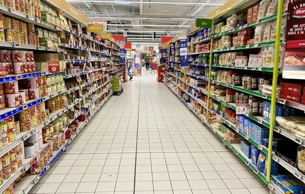 Allée centrale d'un supermarché, illustrant l'environnement d'achat des produits alimentaires.