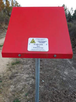 Borne haute de RTE signalant une liaison souterraine haute tension de 63 000 volts, au bord d’une piste DFCI en Dordogne.