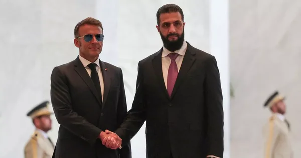Emmanuel Macron serrant la main d'un responsable syrien lors de sa visite à Damas.