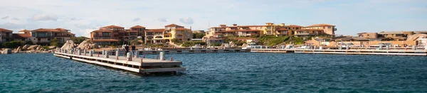 Le port de Cavallo, avec sa jetée en bois et ses villas luxueuses sur fond de rochers.