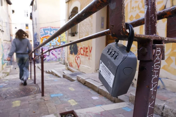 Cadenas sur une rambarde dans une ruelle de Marseille, symbole des mesures de la ville contre les locations illégales.