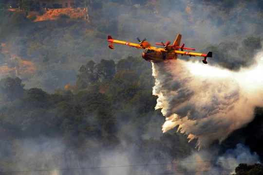 Un Canadair larguant du retardateur de flamme sur un incendie de forêt.