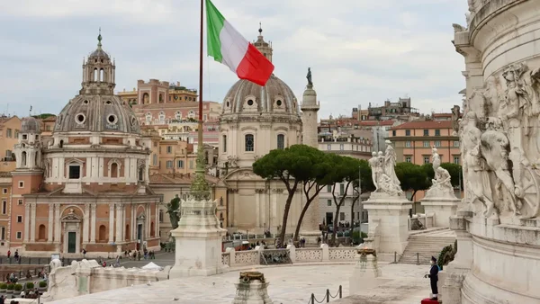 Drapeau italien flottant sur la Piazza Venezia à Rome, symbole national pour illustrer le chômage au plus bas