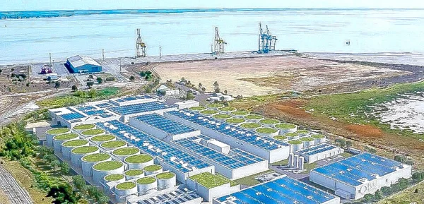 Rendu architectural du projet Pure Salmon, montrant les réservoirs de stockage et les panneaux solaires en bord de mer.