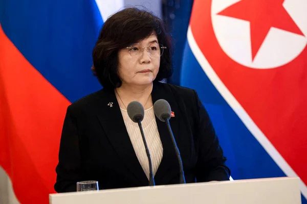 Choe Son-hui lors d'une conférence de presse en Russie, aux côtés des drapeaux nord-coréen et russe.
