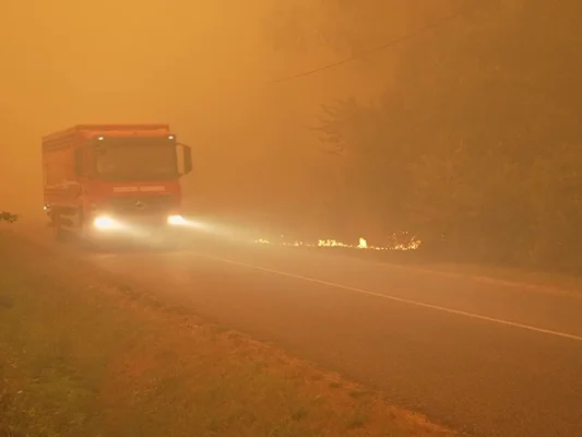 Un camion de pompiers traverse une zone enfumée par les incendies en Gironde.