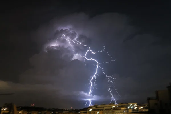 Violent orage dans le Sud-Ouest : un éclair déchire le ciel nocturne au-dessus d'une zone urbaine.