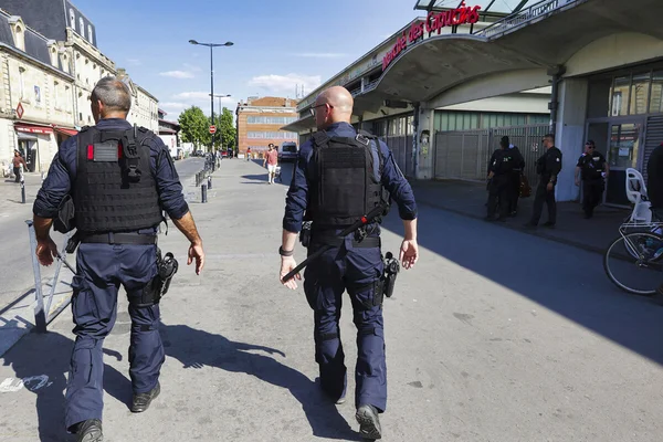 Patrouille de policiers en tenue tactique devant le Marché des Capucins.
