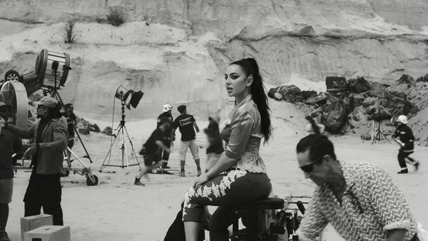 Scène des coulisses du clip de Charli XCX avec Vincent Cassel, dans un décor hollywoodien en plein désert.