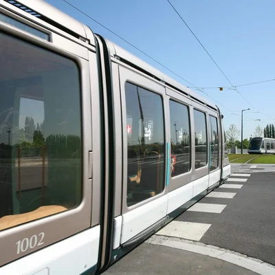 Tramway moderne numéro 1002 circulant en extérieur par temps ensoleillé.