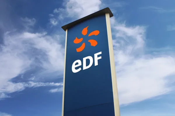 Enseigne d'EDF avec son logo emblématique sous un ciel ensoleillé.