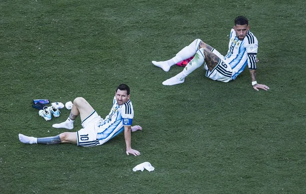 Joueurs argentins épuisés sur la pelouse après un match.