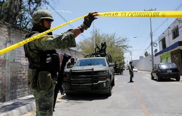Un soldat mexicain bloque une rue après une embuscade meurtrière contre des policiers.