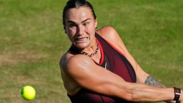 Joueuse de tennis en action sur un court en gazon.