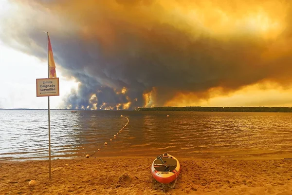 Fumée d'un incendie de forêt s'élevant au-dessus d'un lac près de Bordeaux, un phénomène d'orage de feu.