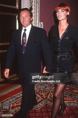 Gérald Marie et une femme rousse marchant sur un tapis à motifs (image avec filigrane).