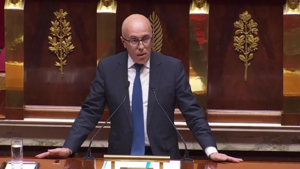 Éric Ciotti au pupitre de l'Assemblée nationale, s'exprimant lors d'une intervention sur le coût de l'immigration.