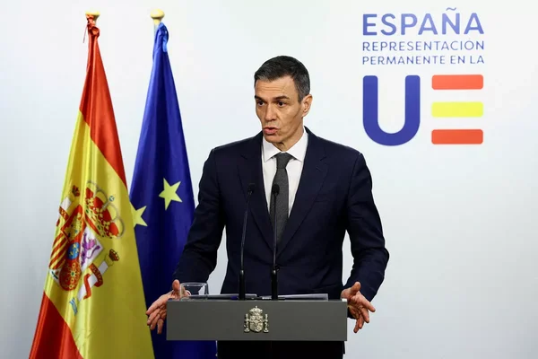 Le ministre de l'Économie lors d'une intervention officielle avec les drapeaux espagnol et européen.