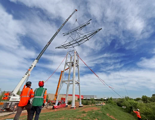 Installation d'un pylône électrique par des techniciens de RTE sous la canicule.
