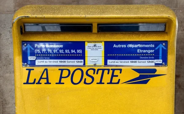 Détail d'une boîte aux lettres jaune avec deux levées distinctes, un service en voie de disparition.