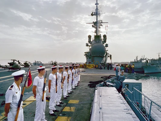Marins français en tenue blanche au garde-à-vous lors d'un déploiement naval.