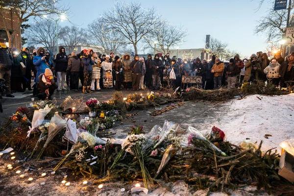 Veillée à Minneapolis en mémoire des victimes, avec un mémorial de fleurs et de bougies sur la neige.