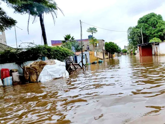 Quartier résidentiel inondé à Lomé, avec des sacs de protection contre la montée des eaux.