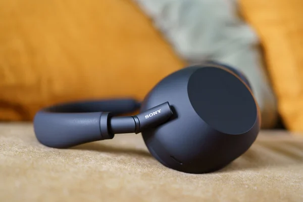 Le casque Sony WH-1000XM6 noir, photographié en gros plan sur un fond beige