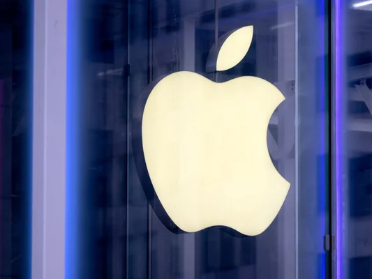 Logo Apple illuminé sur la devanture d'un Apple Store.
