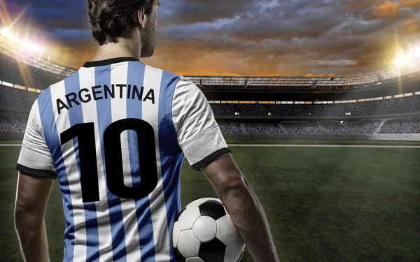 Joueur de football argentin avec le maillot numéro 10, dos tourné, devant un stade bondé.