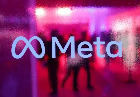 Le logo de Meta sur une surface en verre ou en plastique texturé, éclairé par des lumières roses et violettes.
