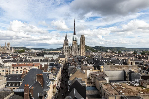 Vue panoramique de Rouen depuis les hauteurs, avec la cathédrale Notre-Dame émergeant au-dessus des toits.