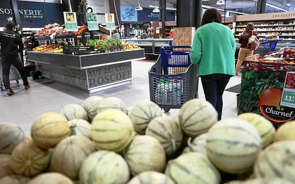 Shoppeuse dans un rayon de fruits et légumes en supermarché.