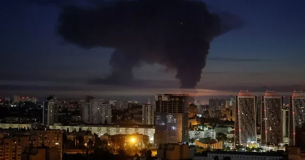 Un panache de fumée noire s'élève au-dessus des immeubles de Kiev lors d'une alerte aux missiles.