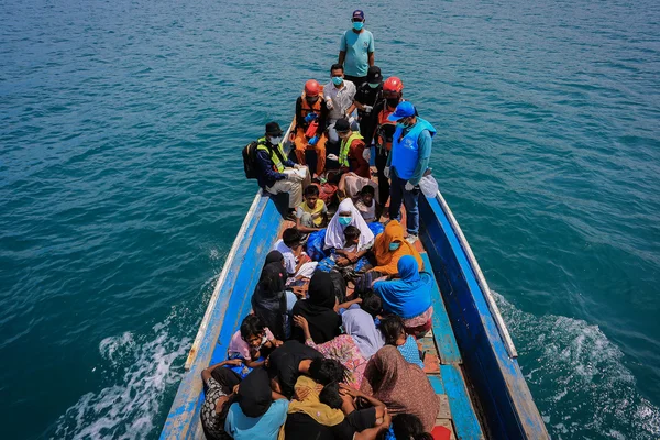 Embarcation surchargée de réfugiés rohingyas en mer, illustrant les traversées périlleuses.