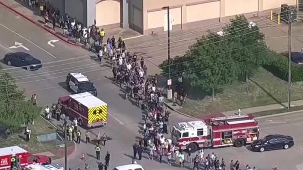 Foule évacuée par les forces de l'ordre après une fusillade dans un centre commercial au Texas.