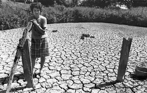 La sécheresse de 1976 : une jeune femme sur le lit craquelé d’un plan d’eau asséché.