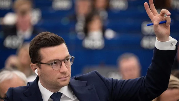 Jordan Bardella levant la main lors d'une séance au Parlement européen.