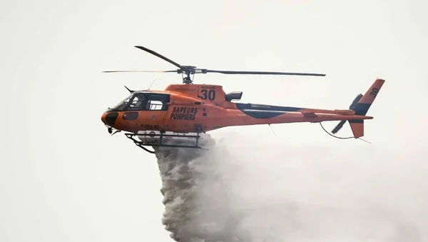 Hélicoptère bombardier d'eau du SDIS du Gard en vol lors d'une mission de lutte contre un incendie.