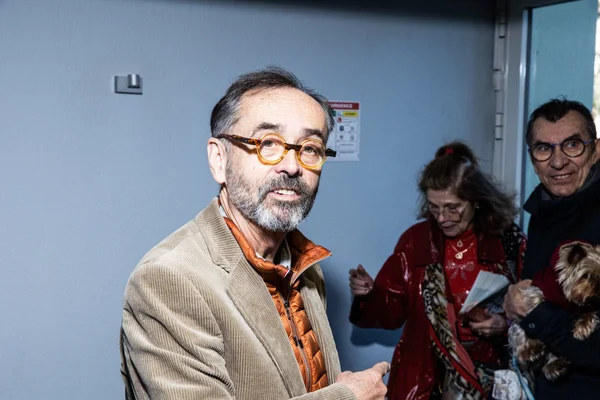 Robert Ménard debout dans un couloir, entouré de collaborateurs.