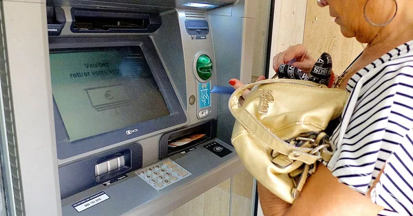 Femme utilisant un distributeur automatique de billets.