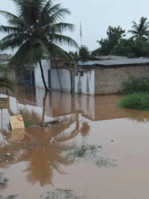 Quartier résidentiel de Lomé sous les eaux, avec des bâtiments partiellement submergés.