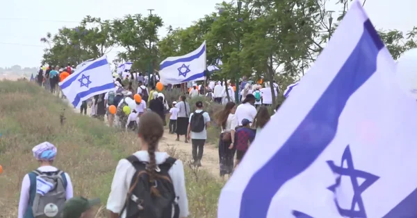 Des colons israéliens et leurs sympathisants, brandissant des drapeaux et des ballons orange, marchent vers la bande de Gaza pour réclamer le rétablissement des colonies.