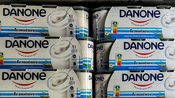 Packs de yaourts Danone 'le nature' empilés, avec étiquettes nutritionnelles visibles.
