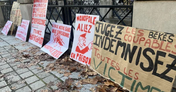 Pancartes de protestation contre le chlordécone et les Békés, déposées sur un trottoir.
