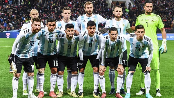 Photo d'équipe de l'Argentine avant un match, avec les joueurs en maillots rayés bleu et blanc.