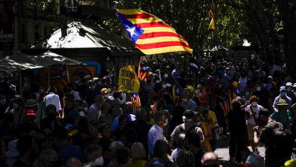 Défilé de manifestants indépendantistes catalans masqués dans une rue arborée