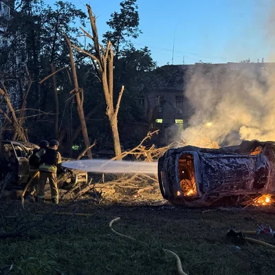 Des pompiers interviennent sur un véhicule en feu après une attaque de missiles et de drones sur Kiev.