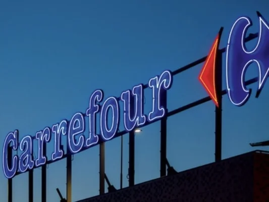 Enseigne lumineuse Carrefour au crépuscule.